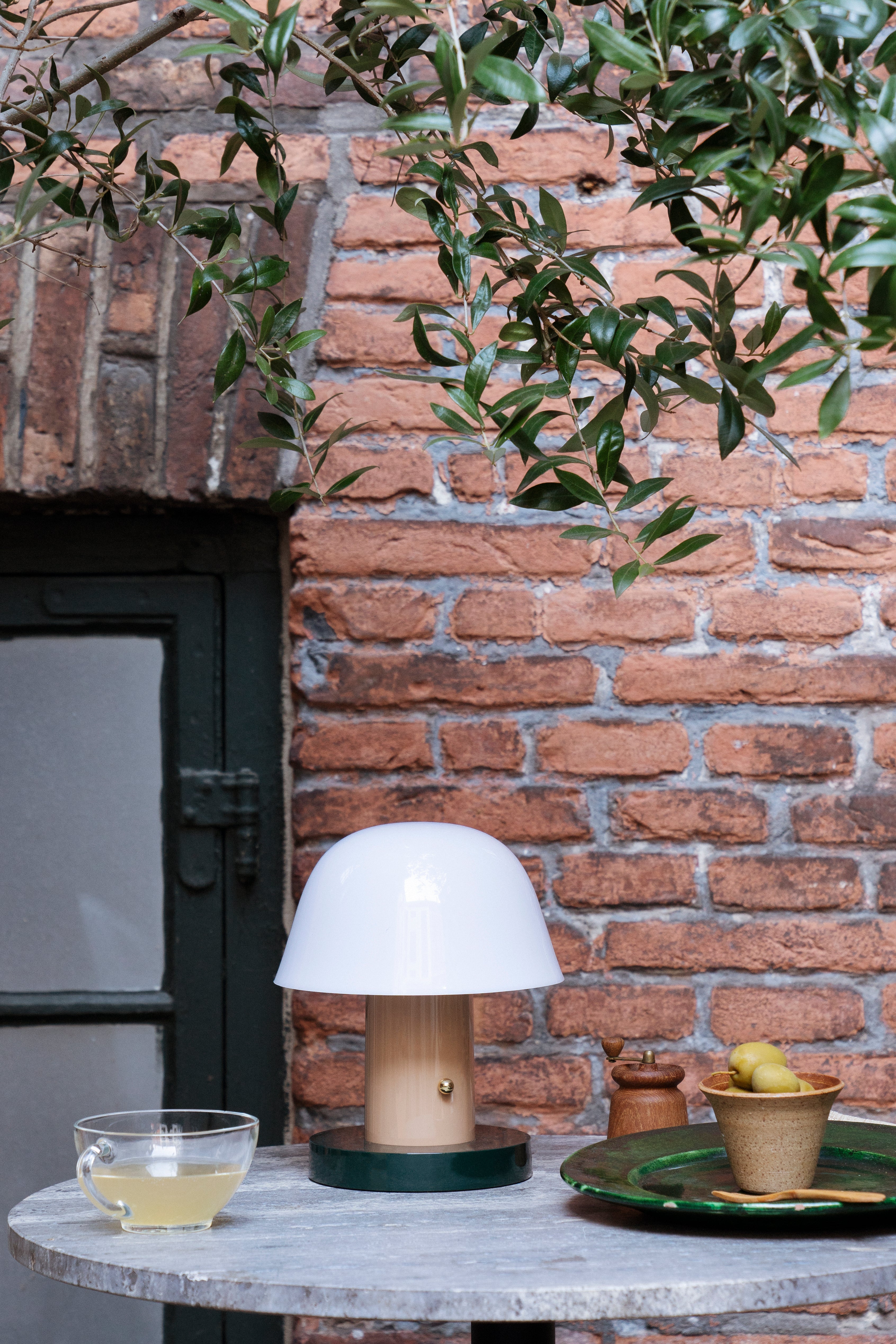 Draagbare lamp SETAGO JH27 met een crèmekleurige kap en een beige-groene voet.