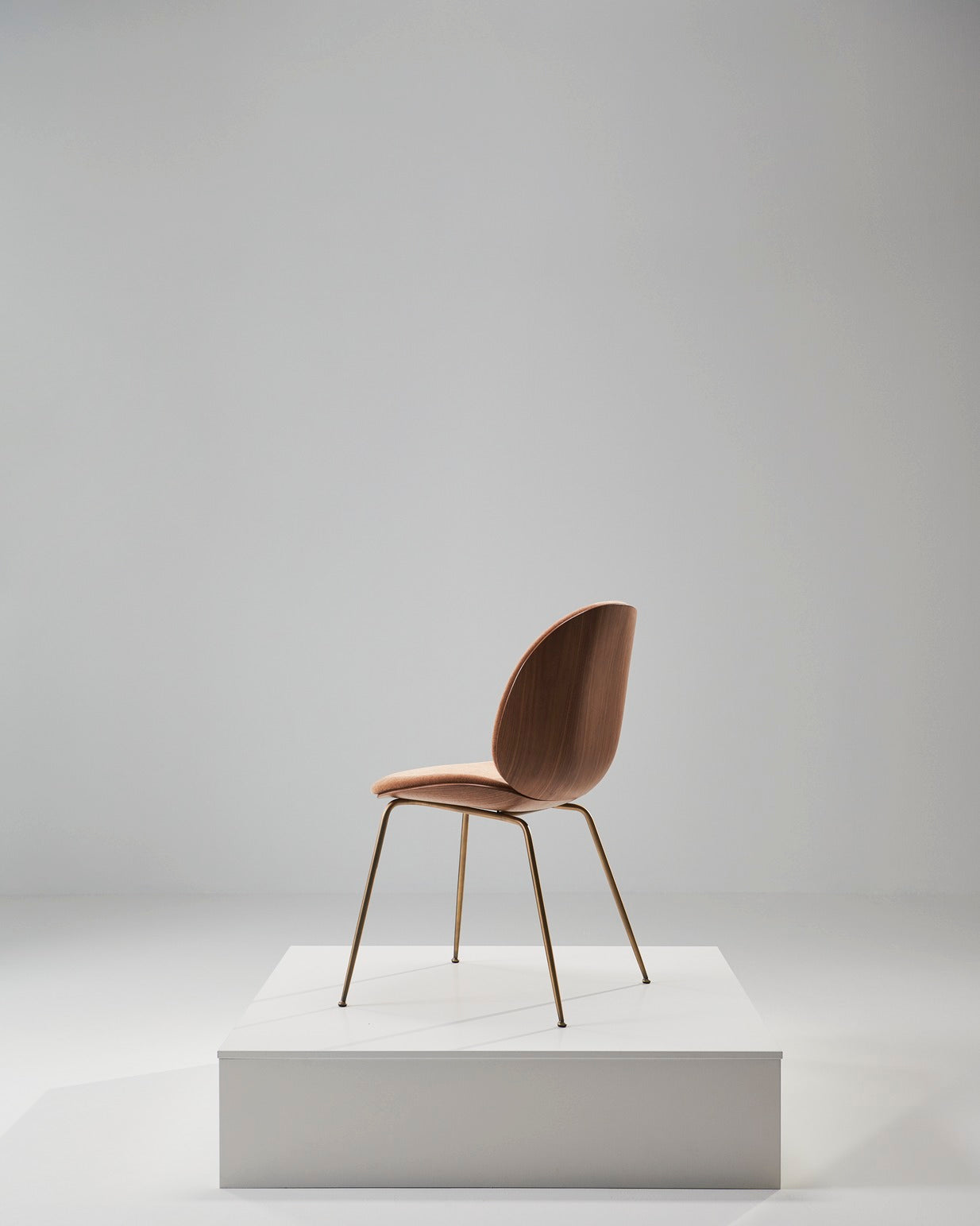 Beetle stoel, gestoffeerd met notenhout en een messing basis