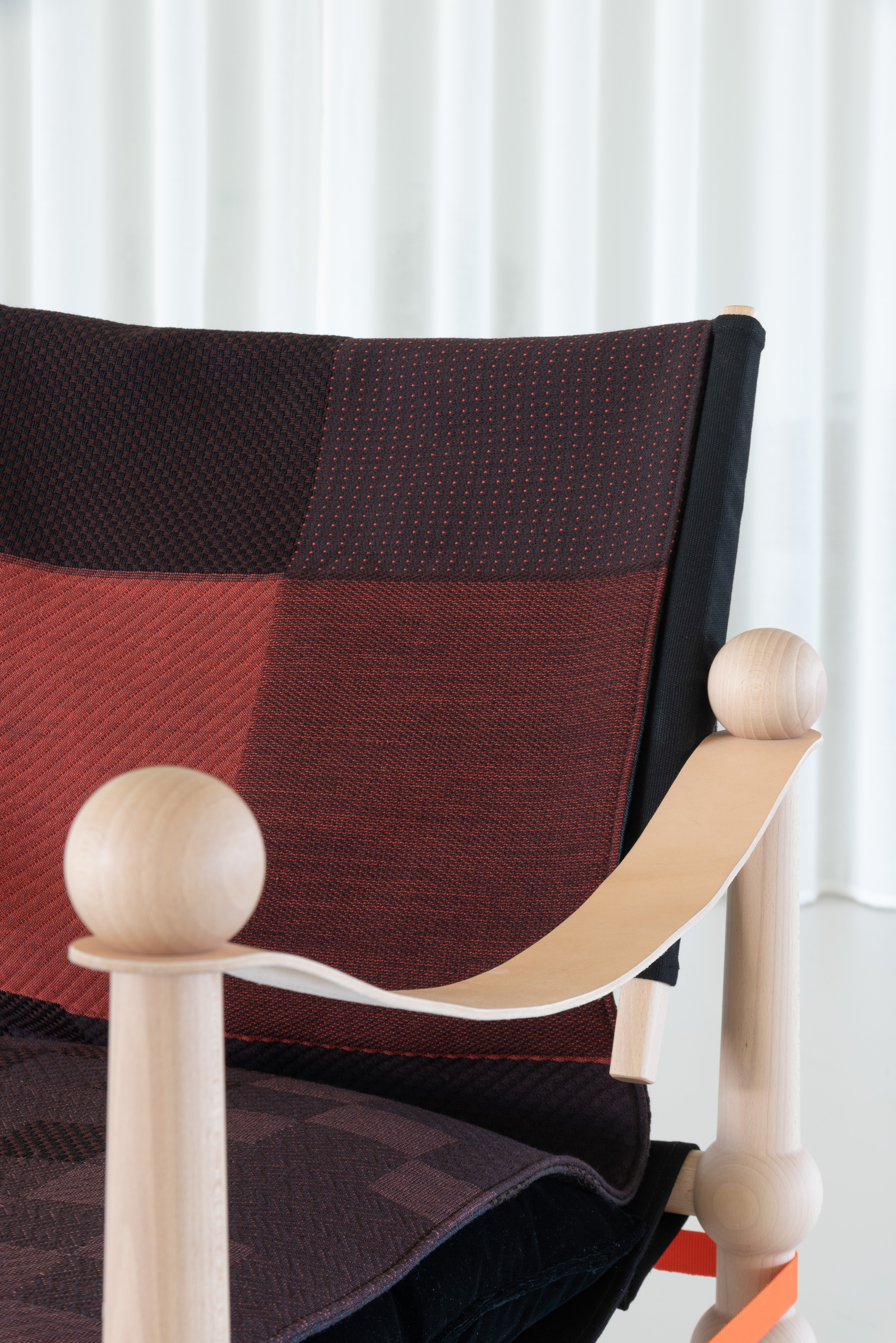 TWAIN armchair with a brown-purple blanket and a light beech base