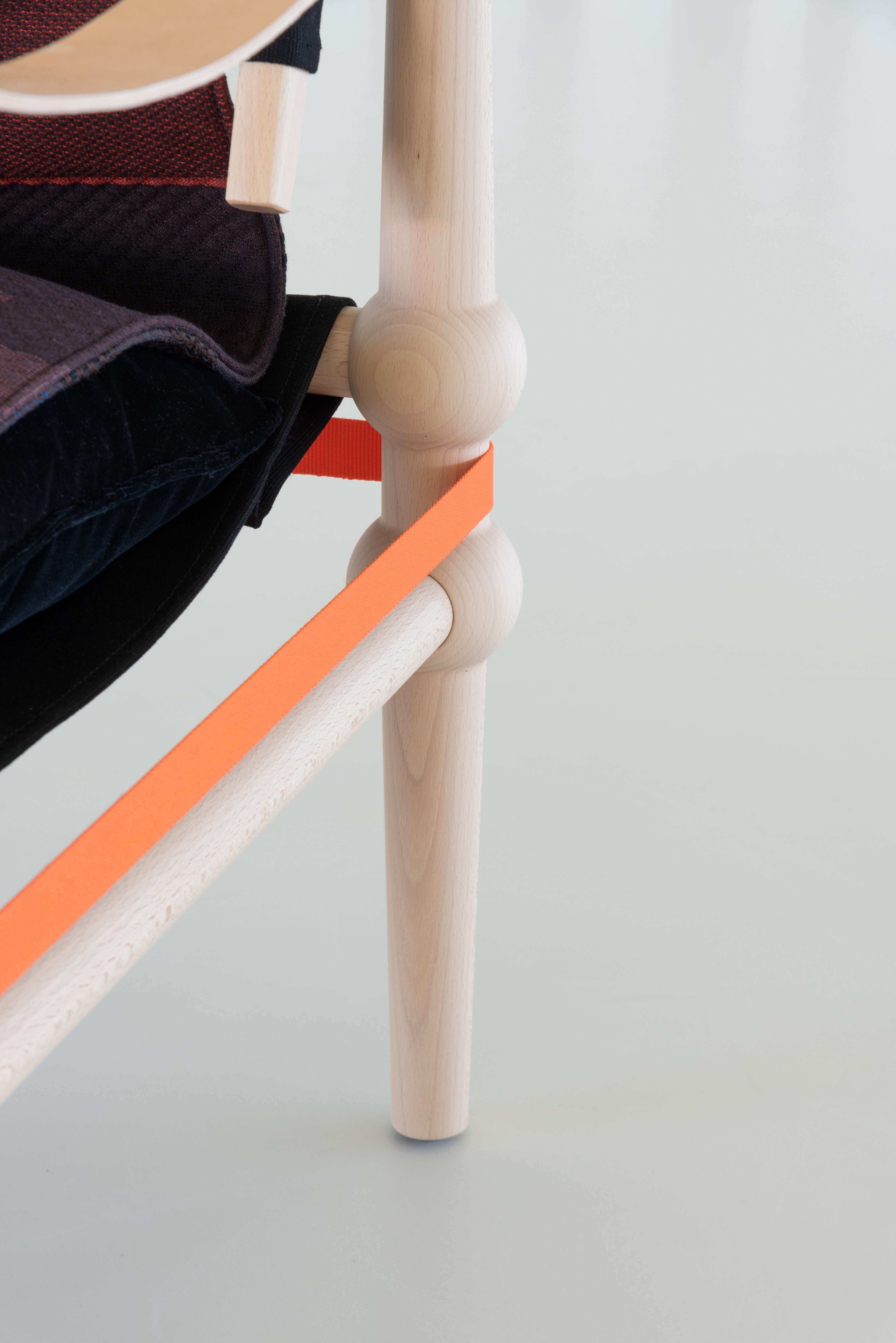 TWAIN armchair with a brown-purple blanket and a light beech base