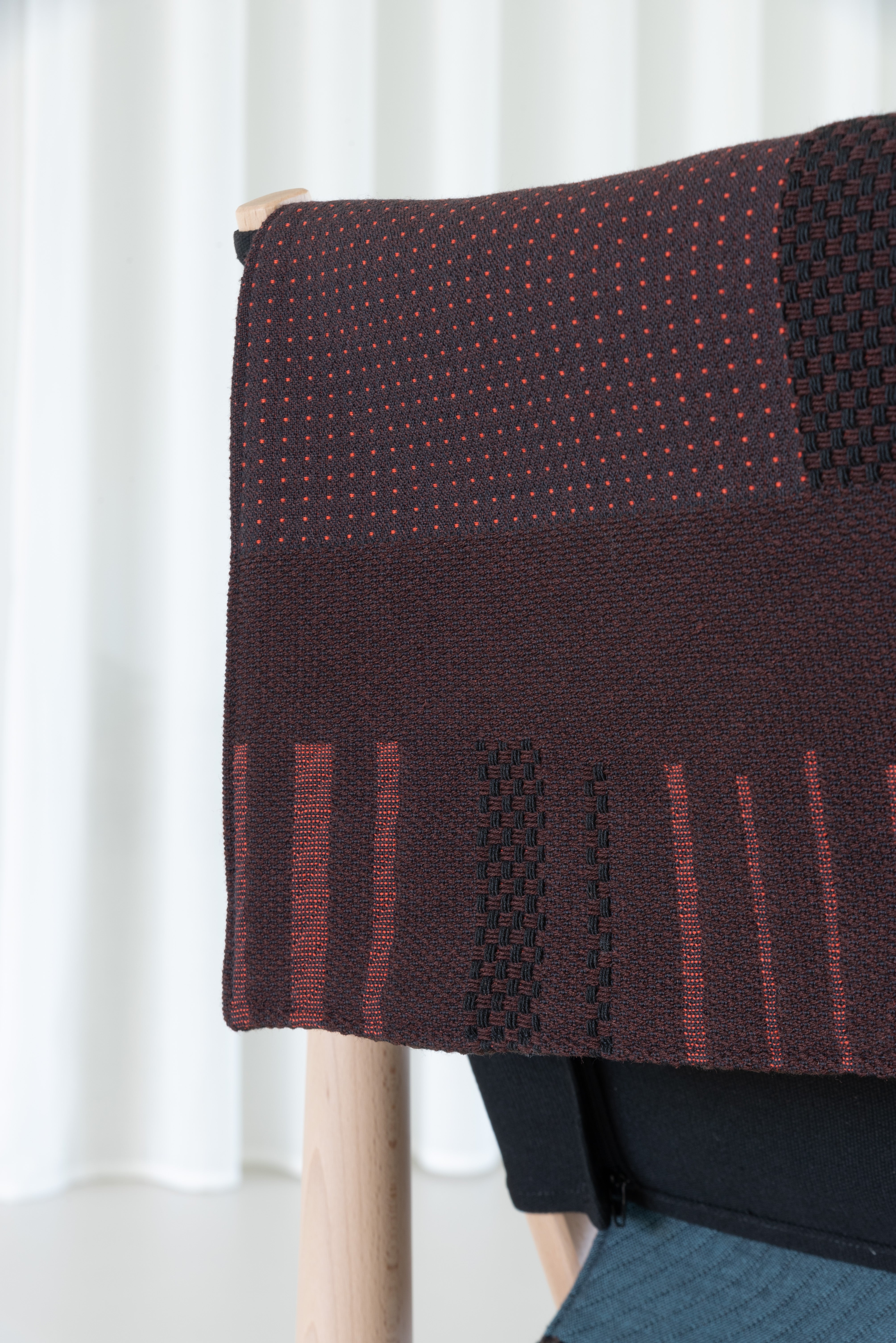 TWAIN armchair with a brown-purple blanket and a light beech base