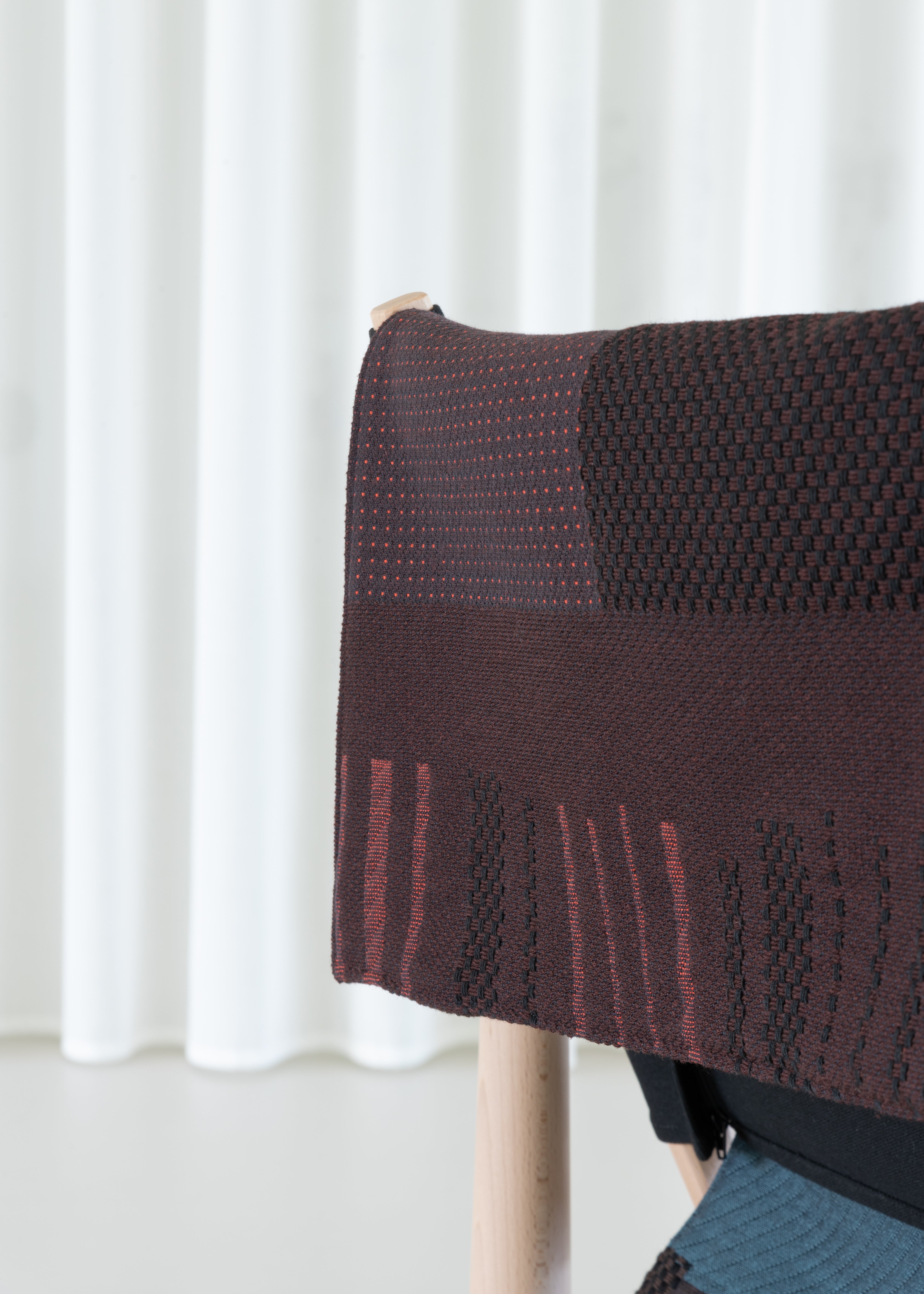 TWAIN armchair with a brown-purple blanket and a light beech base