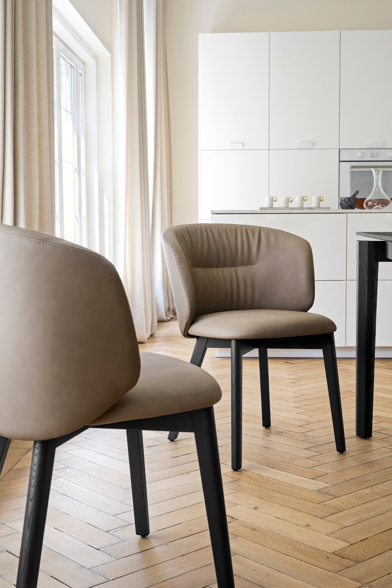 Upholstered SWEEL chair with a dark wooden base