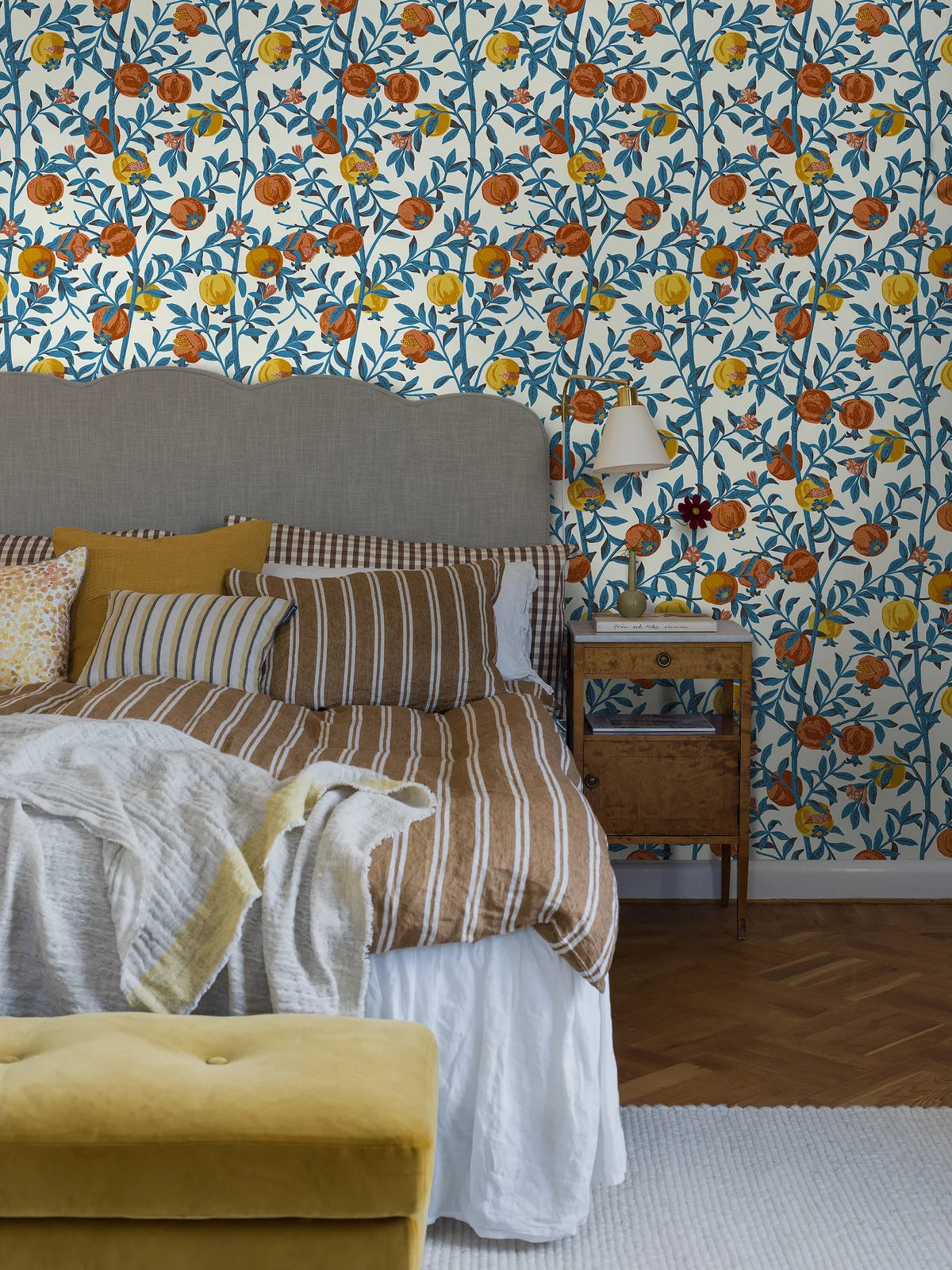 Behang met een plantaardig patroon van granaatappelvruchten wit met blauw en oranje
