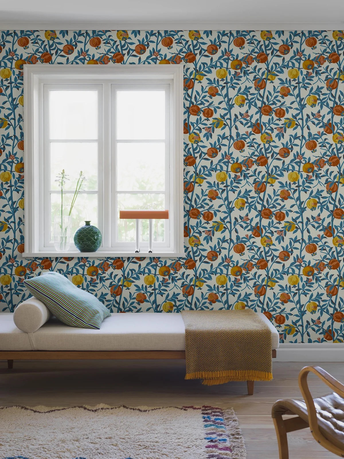 Behang met een plantaardig patroon van granaatappelvruchten wit met blauw en oranje