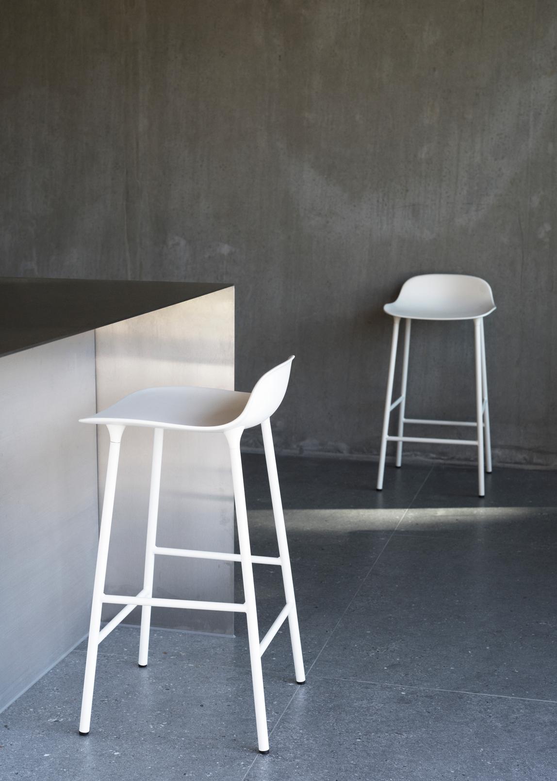 Hocker bildet warmes Grau mit einer Chrombasis