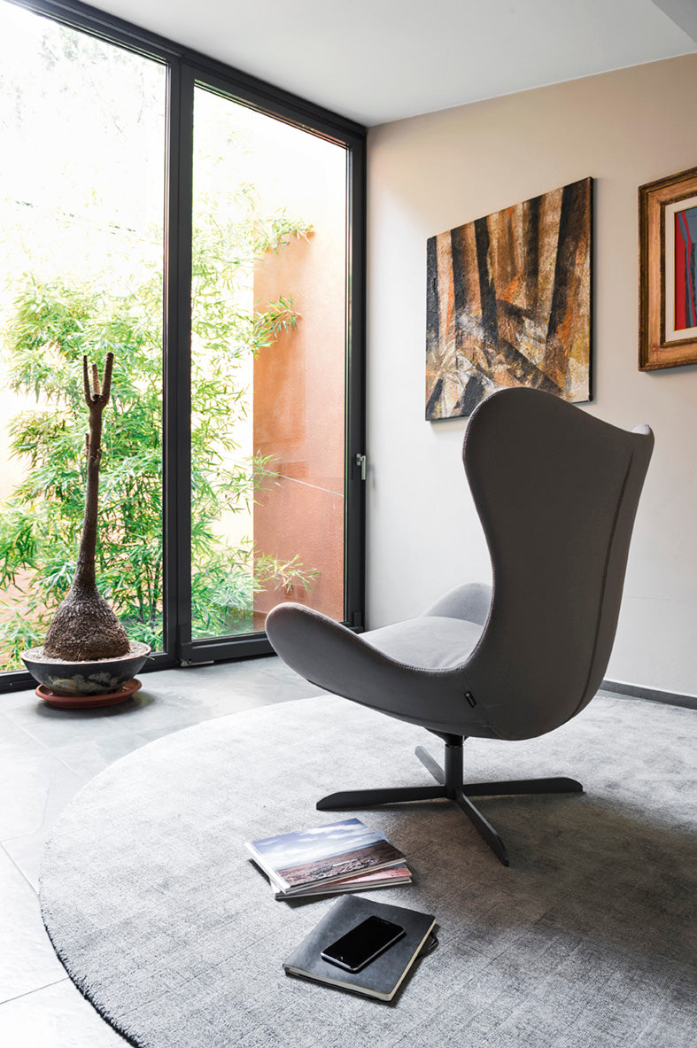 LAZY upholstered swivel armchair with a black metal base