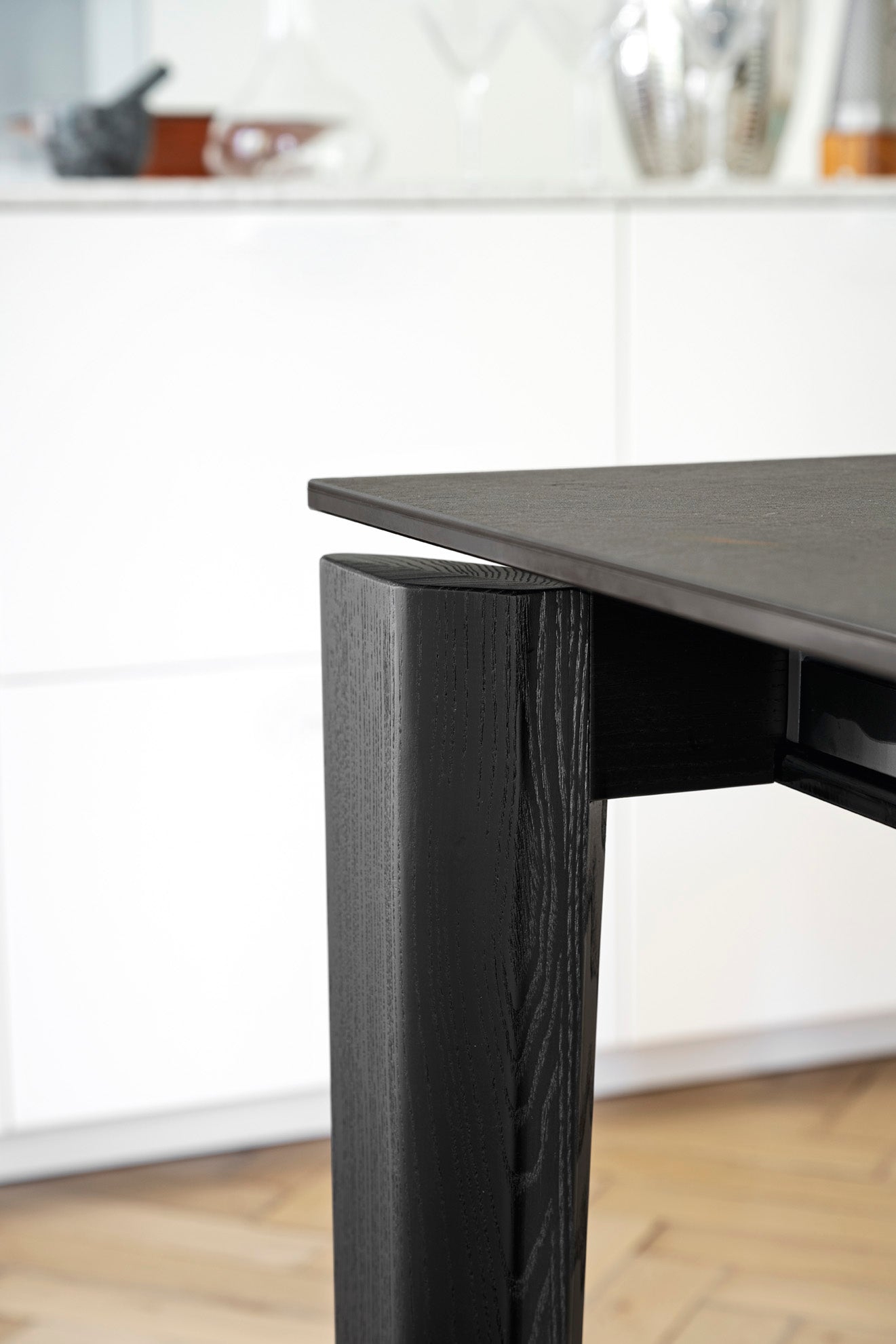 Uitschuifbare tafel DOGMA met een wit blad en een zwarte houten basis